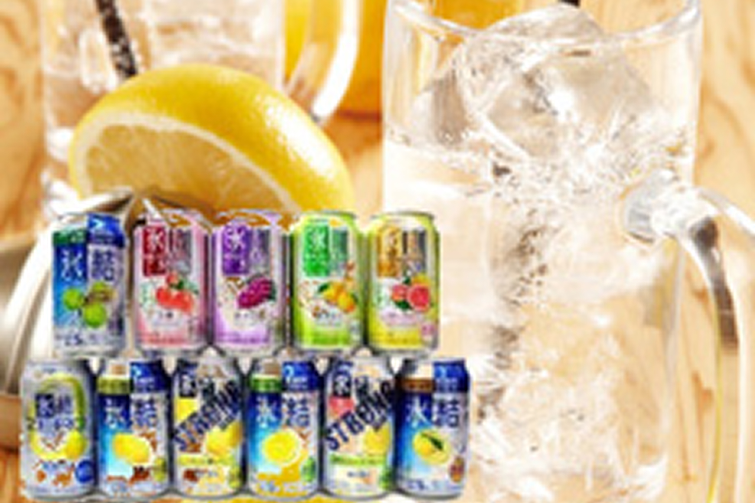缶チューハイのパッケージが並んでおり背景に氷の入ったグラスとレモン