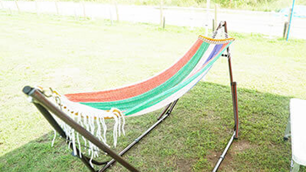 原っぱにカラフルな色のハンモックが設置されている写真