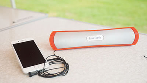 テーブルの上にスマートフォンに接続された音楽スピーカーがある写真